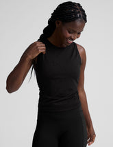 model wearing a scoop high neck racerback tank top against a plain background.